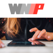 Person typing on a tablet with WNIP logo at the top